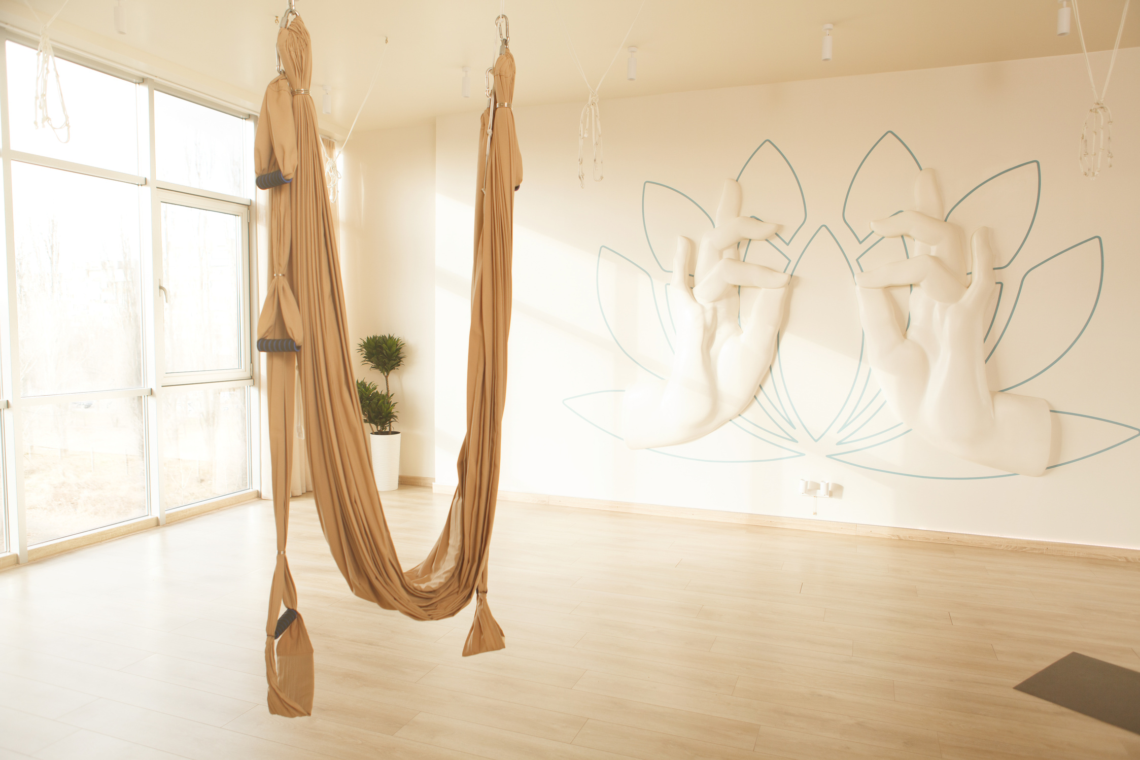 Aerial yoga hammock hanging at empty yoga studio, copy space
